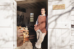 Ramona Vogel Hill in the doorway of the new cooper shop in the George Wythe Lumber House,