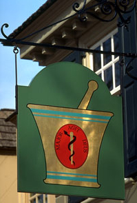 The mortar and pestle sign hanging in front of the Pasteur & Galt Apothecary Shop indicates the nature of the business within.