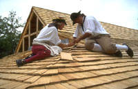 Carpenters lay shingles on the roof of a shed near Shields Tavern in The Revolutionary City.