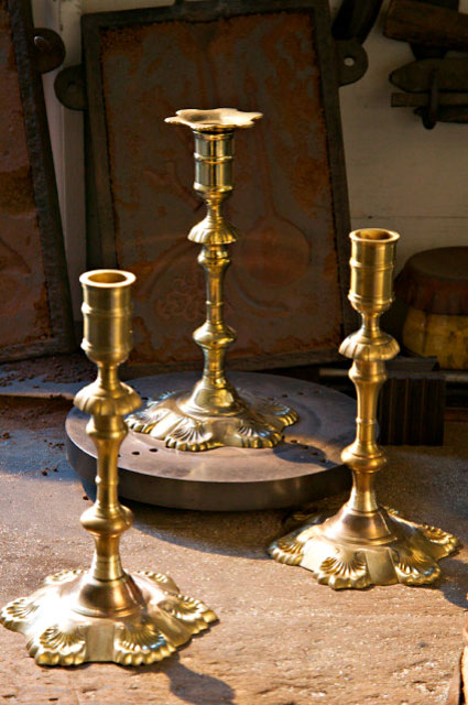 Hand-cast, hand-finished candlesticks sit on a workbench in the James Geddy Foundry.