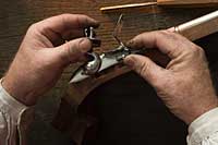 A gunsmith performs detail work on the stock of an American long rifle. 