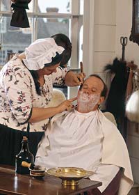 The wigmaker shaves and barbers her clients.