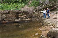Heavy rain released the timbers of Falling Creek's furnace base from centuries of mud. Ralph Lovern and Lyle Browning look on.