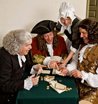 From left, interpreters Russell Wells, John Hamant, and Dennis Watson mix wine and wagers at a tavern card table.