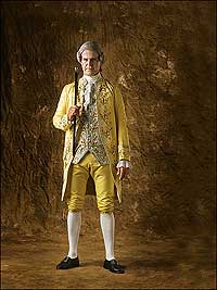 Actor-interpreter Dennis Watson wears a yellow-silk floral-embroidered coat and breeches with a coordinated white-silk satin waistcoat.