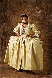 Actor-interpreter Janine Harris models a pale-yellow changeable silk mantua and extreme side hoops of the 1740s with a brown-silk quilted petticoat, wool-embroidered-on-linen stomacher, hand-built rust-silk-covered heeled shoes with buckles and a lace lappet cap, all from Colonial Williamsburg's Millinery Shop.
