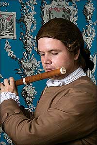 Colonial Williamsburg's Andrew DeLisle tootles a wooden flute to keep the dancers turning to the tunes during holiday season.