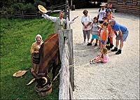 Interpreters Carrie MacDougal and Eric Hunt talk about the history of the Devons, as well as the rare breeds program, to guests in the Historic Area: the Savercool family from New Jersey, the Tombros from New York, and Michael and Sally Woodard from Florida.