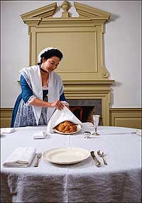 Interpreter Bereni New sets the table with a loaf of <i>challah,</i> the braided egg bread used for the Sabbath and the High Holy Days.