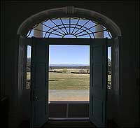 The lobby looks toward the Blue Ridge Mountains beyond the fields of the estate.