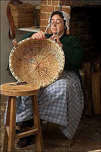 Terry Thon weaving strips into a basket; technique determines a tight or loose weave.