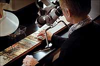 Among the tools employed by conservators is a microscope to work on details too fine to see with the naked eye.