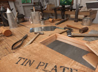 Tools of the trade and sheets of tin: iron coated with molten tin