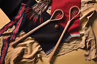 Two Cherokee ballsticks, a leather ball stuffed with deer hair, and a beaded sash to hold up the red-and-blue breechcloths