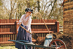 Lindsey Foster, 
an interpreter at the Peyton Randolph House, works on chores 
in the backyard.