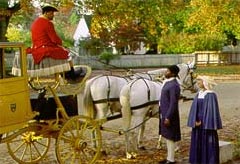Joe Jones, driving the Wythe chariot, pauses in front of Bruton Parish Church to speak to African American character interpreters Robert M. Watson Jr., and Sylvia Lee. All three are costumed for their roles as urban household slaves.