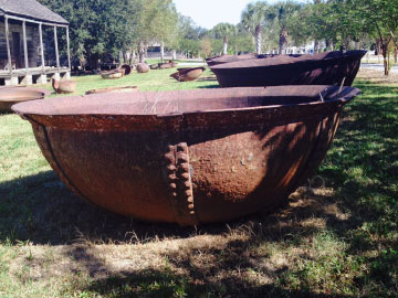 Credit: Whitney Plantation Sugar kettles and slave cabins