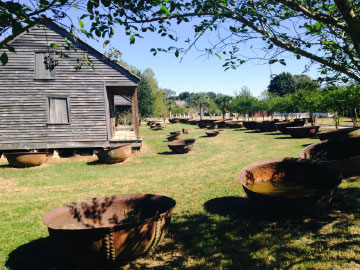 Credit: Whitney Plantation Sugar kettles and slave cabins