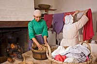 Interpreters Hope Smith and Deborah Lees wash clothes in the Benjamin Powell House kitchen and laundry.