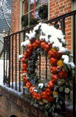 Snow-kissed red apple garland wreath at the Margaret Hunter milliner shop